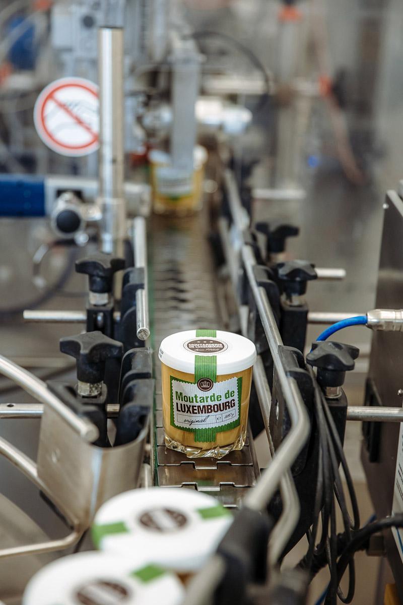 Un pot de moutarde sur la ligne de production